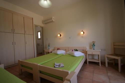 帕罗奇亚茉莉花酒店的一间位于客房内的带绿床的卧室