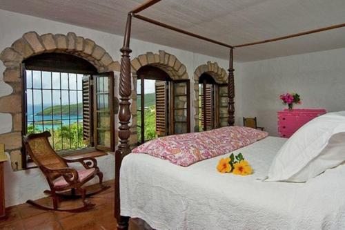 Crescent BeachSugar Reef Bequia - Adults Only的一间卧室配有一张床、一把椅子和窗户。