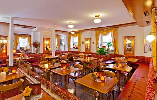 马克特奥伯多夫Hotel Greinwald的餐厅设有木桌和红色椅子