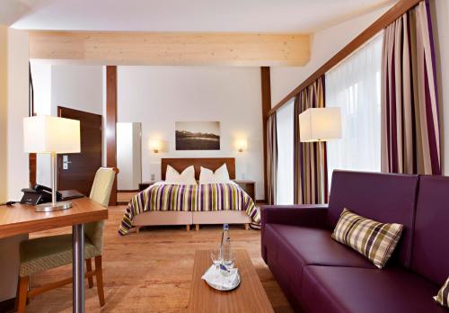 马克特奥伯多夫Hotel Greinwald的酒店客房设有一张床和一张紫色沙发