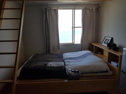 宫崎Ocean Home Guest House的一间卧室配有双层床和窗户。