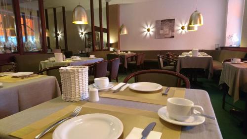 特里尔德切仁或福酒店的一间设有桌椅、白板和杯子的餐厅