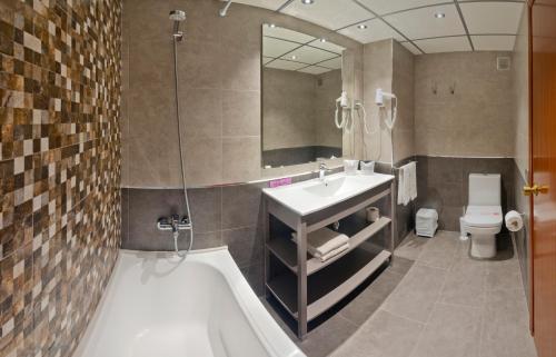 坎布里尔斯沃拉马尔坎布里尔斯公寓的一间带水槽、浴缸和卫生间的浴室