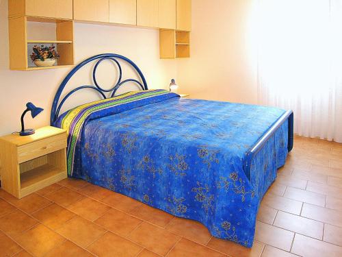 比比翁Appartamenti Nasse的一间卧室配有一张带蓝色棉被的床