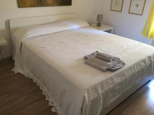 卡斯拉诺Mansarda Caslano的一张白色的床,上面有一条毛巾