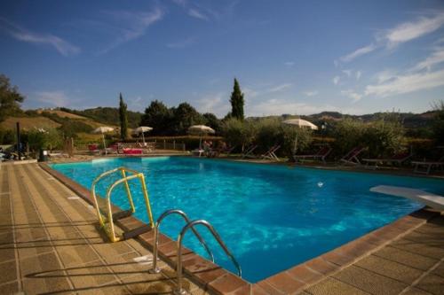 古比奥Agriturismo Castello Di San Vittorino的一座蓝色海水和楼梯的大型游泳池