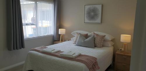 罗托鲁瓦Rose Apartments Unit 6 Central Rotorua-Accommodation & Spa的一间卧室配有带毛巾的床