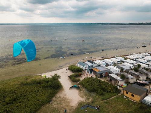 弗瓦迪斯瓦沃沃Pokoje Surf People的一群房子在海滩上空飞翔的风筝