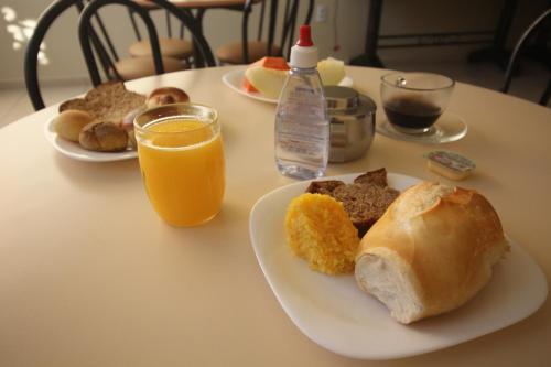 DianópolisMosaico Hotel的一张桌子,上面放着两盘早餐食品和橙汁