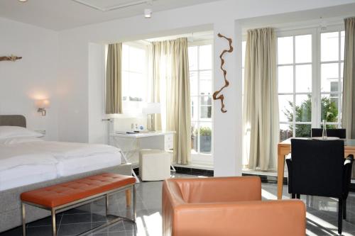 宾茨Atelier-Appartement Ambienta im Zentrum von Binz的卧室配有一张床、一张桌子和椅子