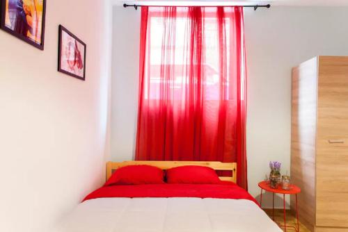 海若克利欧Studio for Couples near Downtown的一间卧室配有红色窗帘和一张床