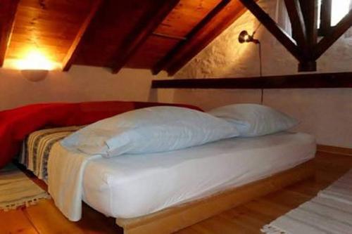 PalaiókastronTraditional Greek Cottage的铺有木地板的客房内的一张白色床