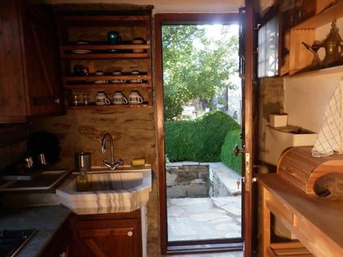 PalaiókastronTraditional Greek Cottage的厨房设有水槽和滑动玻璃门