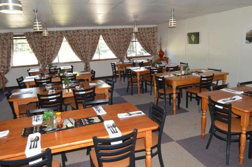 BokongMotebong Lodge的用餐室配有木桌和椅子