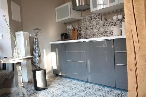 特里尔Exklusive Designferienwohnung The Backyard TBY 02的厨房配有蓝色橱柜,铺有瓷砖地板。
