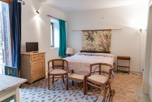 帕斯加特Pescalina - Pescate的一间卧室配有一张床、两把椅子和电视