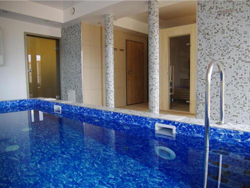 乌涅尤夫尤尼约酒店的浴室设有蓝色浴缸和镜子