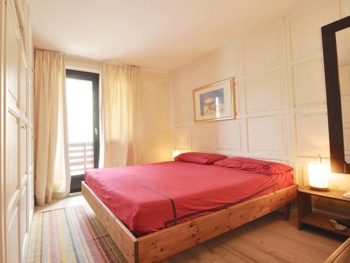 拉特乌伊莱Design loft ski in ski out的一间卧室配有一张红色的床和窗户