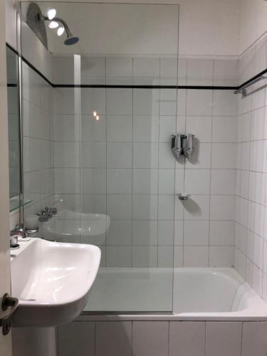 布宜诺斯艾利斯Madero Apartment的浴室配有盥洗盆、浴缸和盥洗盆
