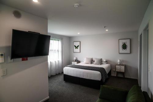 克伦威尔中央公园公寓式酒店的一间卧室配有一张床和一台平面电视