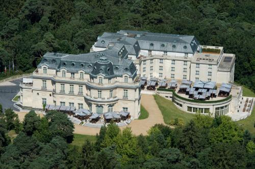 拉沙佩勒InterContinental Hotels Chantilly Chateau Mont Royal, an IHG Hotel的森林中一座大建筑的空中景观