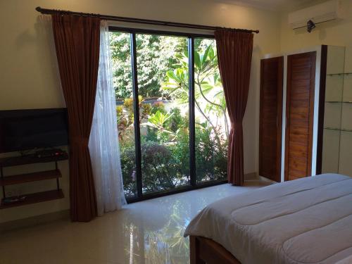 甘地达萨Villa Karma Candidasa的一间卧室设有一张床和一个大窗户