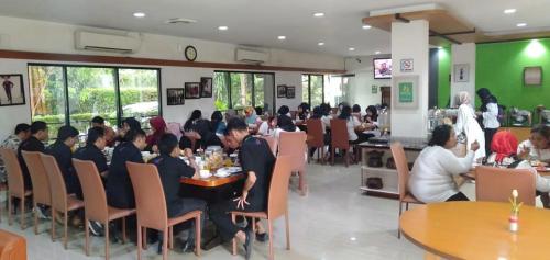 加拉旺卡拉旺英达大酒店的一群坐在餐厅桌子上的人