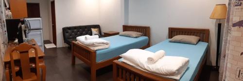 农布Green Mango Resort的一间设有两张床铺和毛巾的房间