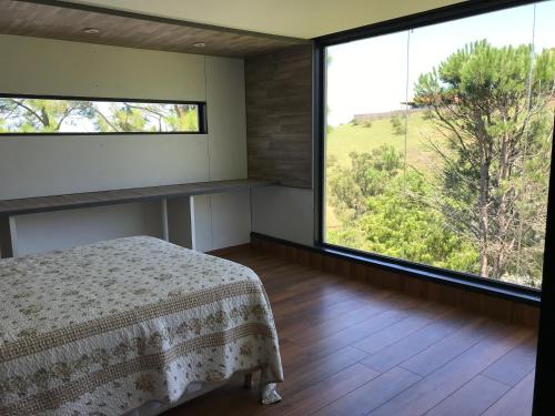 美国别墅城Gran casa del lago的一间卧室设有一张床和一个大窗户
