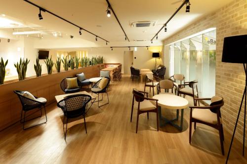 高松WeBase TAKAMATSU的一间在房间内配有桌椅的餐厅