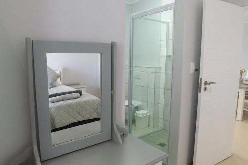 塞吉菲尔德Myoli Holiday Apartments的配有床和浴室的镜子