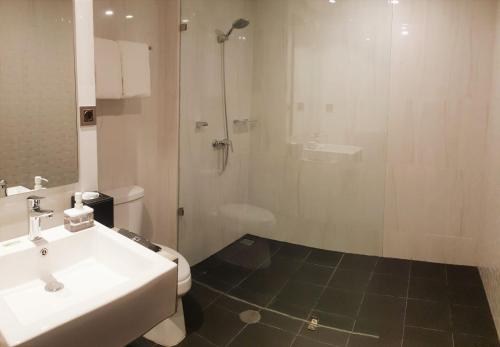 丹戎潘丹BW inn Belitung的带淋浴、盥洗盆和卫生间的浴室