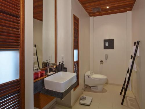 农布芭堤雅别墅酒店的白色的浴室设有水槽和卫生间。