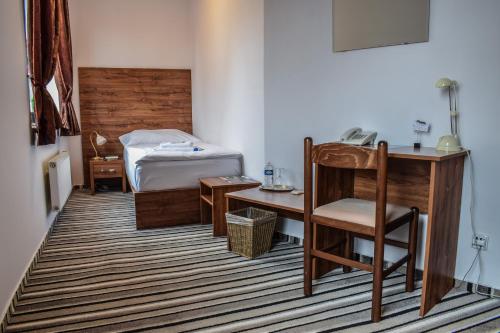 弗里代克-米斯泰克拉罗萨酒店的一间卧室配有一张床、一张桌子和一把椅子