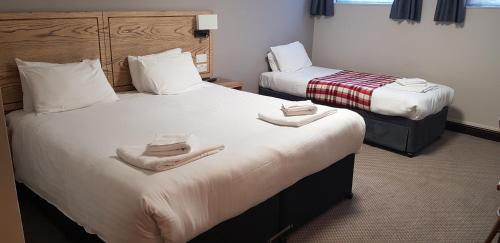 UffculmeWaterloo Cross, Devon by Marston's Inns的两张位于酒店客房的床,配有毛巾