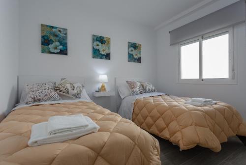 加的斯El TESORO de la Caleta by Cadiz4Rentals的一间卧室设有两张床和窗户。