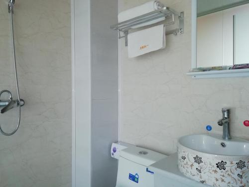 咸阳西安咸阳国际机场一米阳光酒店的白色的浴室设有水槽和卫生间。
