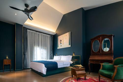 昆明昆明若安·对月楼酒店的卧室拥有蓝色的墙壁,配有一张床和椅子