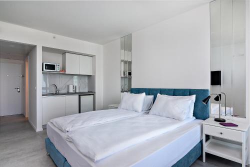内坦亚Netanya SeaView ApartHotel的一间卧室配有一张大床和蓝色床头板