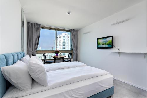 内坦亚Netanya SeaView ApartHotel的酒店客房设有床和窗户。