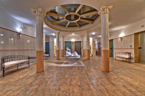 阿巴诺泰尔梅特尔姆帕特里亚酒店的建筑中带柱子和喷泉的大房间