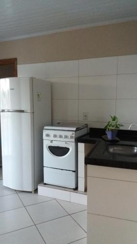 蒙蒂斯克拉鲁斯Apartamento inteiro 2 quartos Wi-Fi的厨房配有白色炉灶和冰箱。