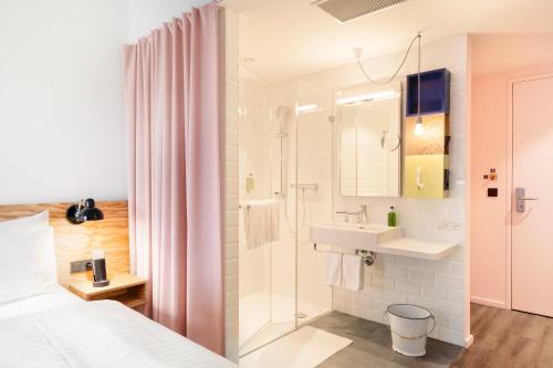 维也纳维也纳沙尼酒店的白色的浴室设有水槽和淋浴。