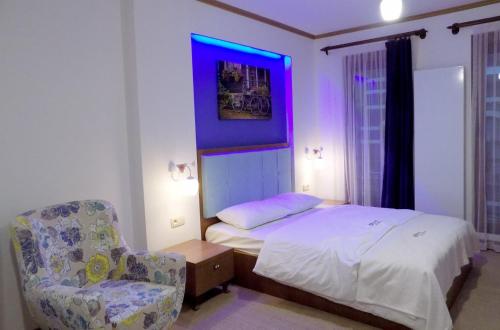 MachelenFly inn Hotel Lounge的一间卧室配有一张床和一张紫色灯椅