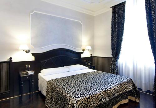 罗马罗马最佳酒店的一间卧室配有一张带黑白毯子的床