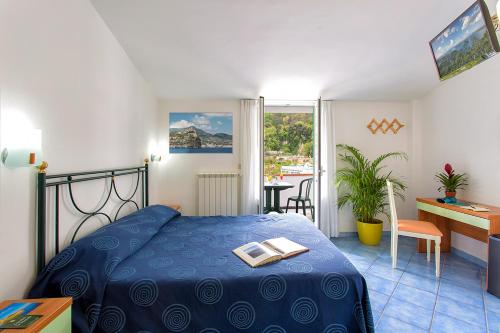 伊斯基亚Hotel Terme Miramonte e Mare的一间卧室配有一张蓝色的床,上面有一本书