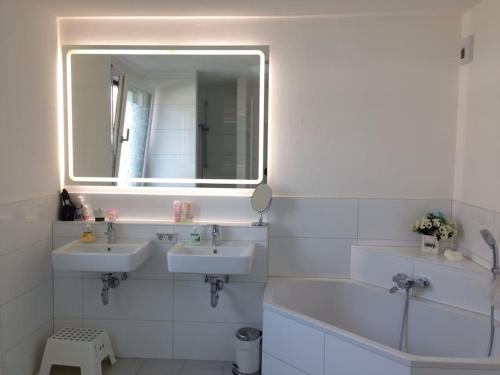 汉诺威Privatzimmer an der Messe的白色的浴室设有两个盥洗盆和镜子