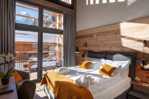 采尔马特22 Summits Boutique Hotel的一间卧室设有一张床和一个大窗户