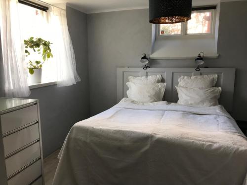 斯塔德Charmigt i centrala Ystad的一间卧室配有带白色床单和枕头的床。