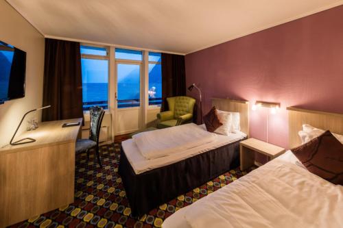 HornindalHavila Hotel Raftevold的酒店客房设有两张床和电视。